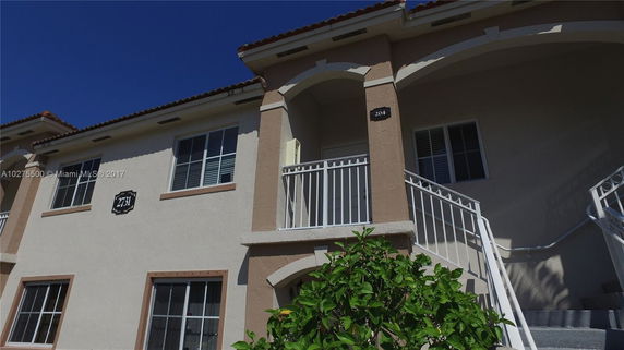Front view of a two-story house with a stairway and balconies.