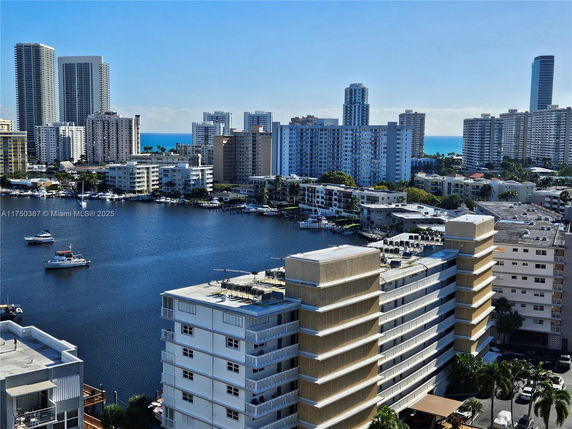 Panoramic view of high-rise buildings overlooking a waterway with boats.
