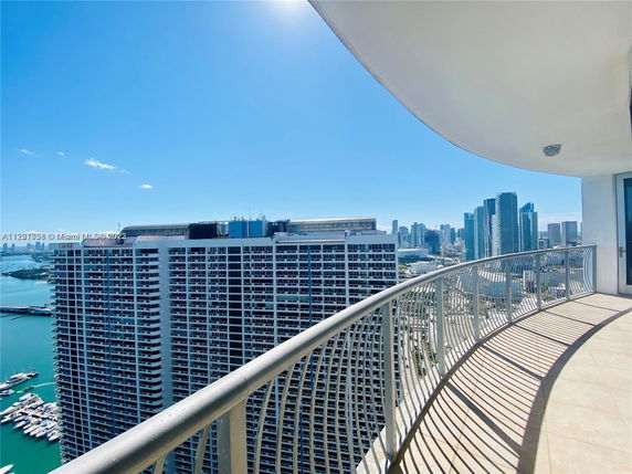 Panoramic view from a high-rise balcony overlooking the city and harbor.