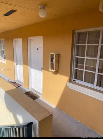 Exterior view of a building with two white doors and a window.