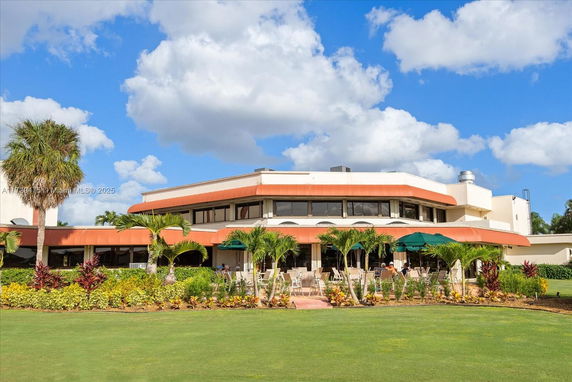 Front view of a two-story building with expansive windows and orange accents.