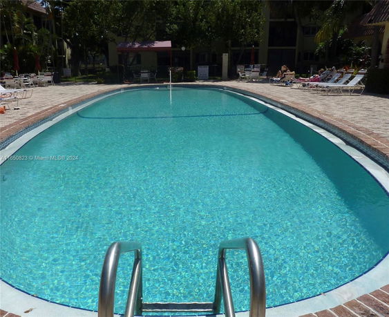 Outdoor swimming pool with surrounding deck and lounge chairs.