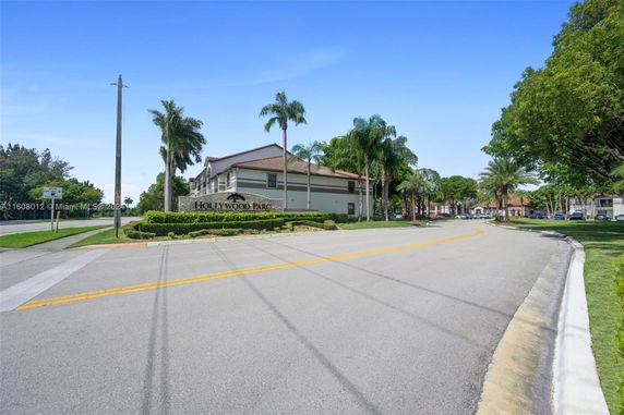 Front view of a building with a sign reading 'Hollywood Parc' and surrounding palm trees.