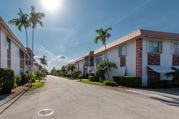 Front view of two-story residential buildings with red-tiled roofs and white walls.