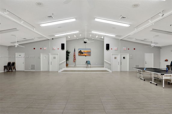 Spacious indoor activity room with stage and recreational equipment