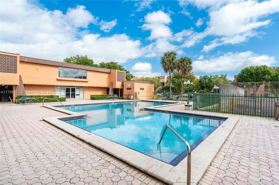 Swimming pool area in front of a modern building.