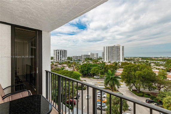 Panoramic view from a balcony overlooking a cityscape with tall buildings.