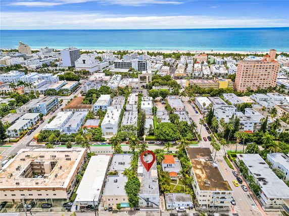 Panoramic view of a coastal city with numerous buildings and the ocean in the background.