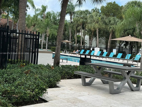 Outdoor swimming pool area with lounge chairs and a picnic table.