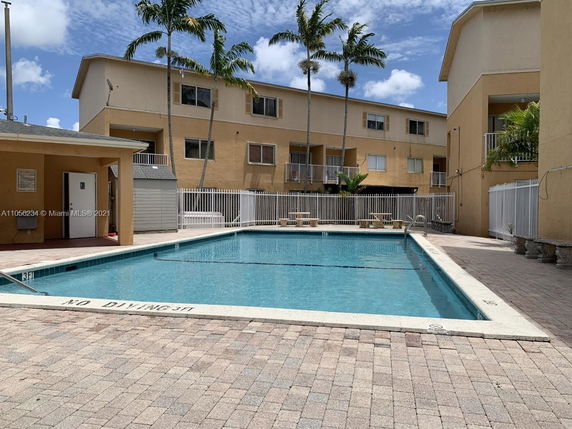 Outdoor swimming pool with apartment buildings in the background.