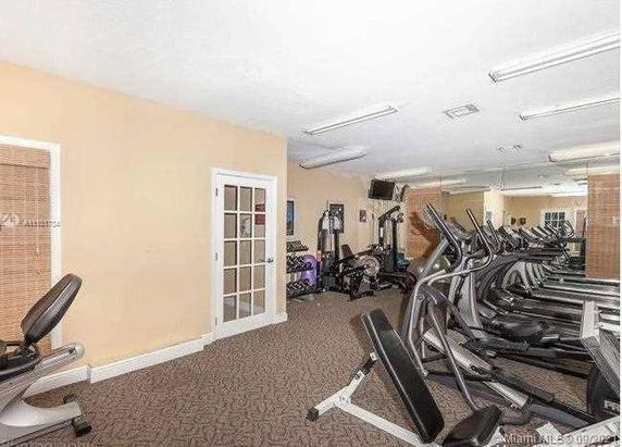Indoor gym area with exercise equipment and mirrors.