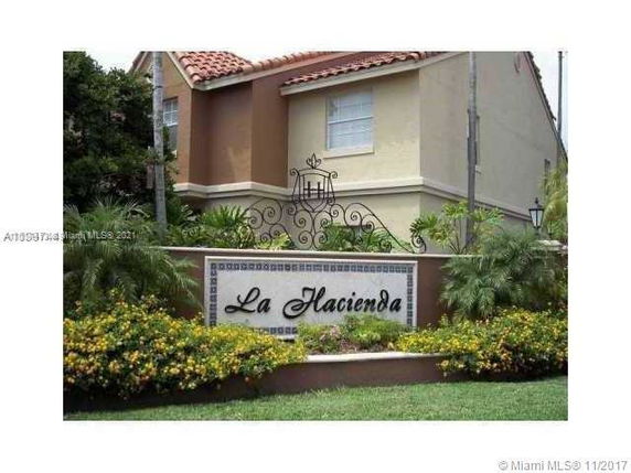 Front view of a building named La Hacienda with a decorative sign.
