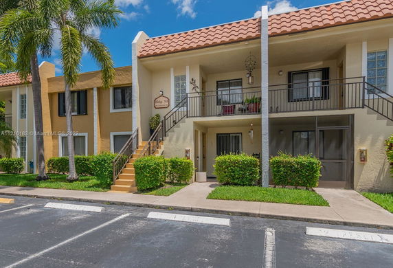 Front view of a two-story apartment building with balconies and stairs.