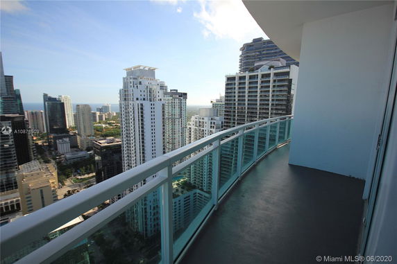 Panoramic view from a high-rise balcony overlooking city skyscrapers.