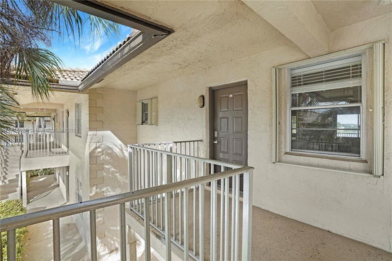 Exterior walkway of a building with railings and a door.
