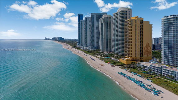 View of a beachfront lined with large residential or hotel buildings.