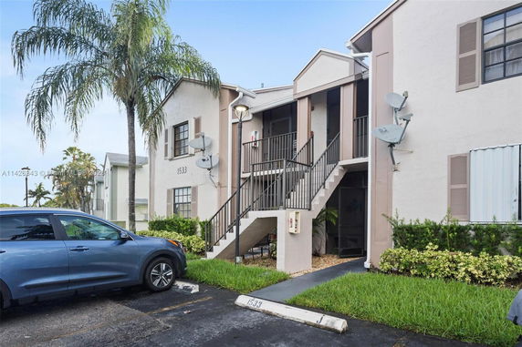 Front view of a two-story building with external staircases and satellite dishes.