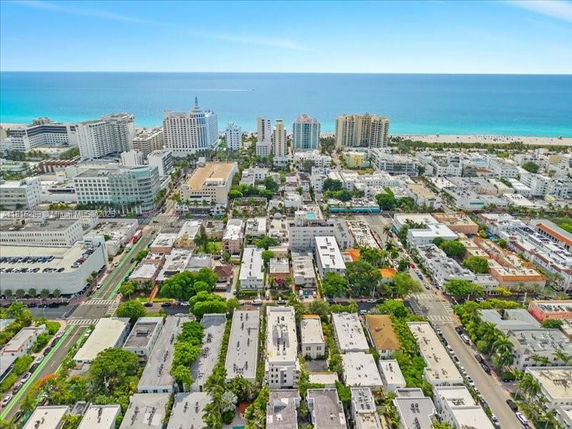 Aerial view of an urban area with high-rise buildings and the ocean in the background.