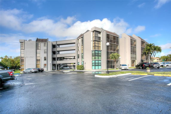 Front view of a multi-story residential building with a parking area.