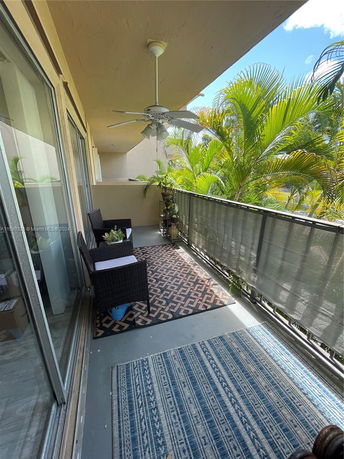 Balcony view with outdoor furniture and ceiling fan.