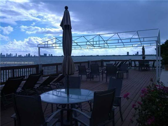 Rooftop deck with seating and a view of the water and city skyline.