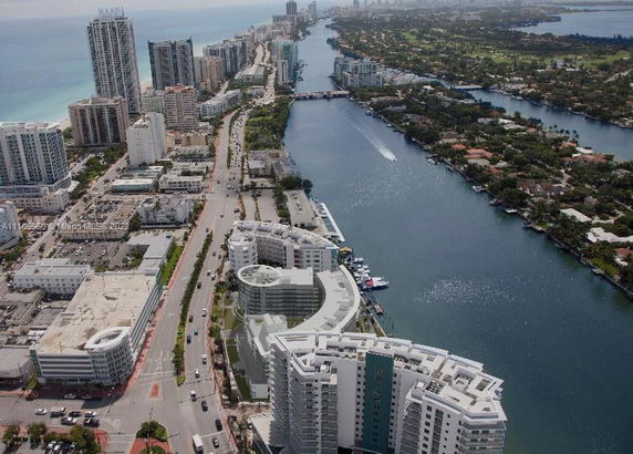 Panoramic view of a coastal cityscape with high-rise buildings and a river.