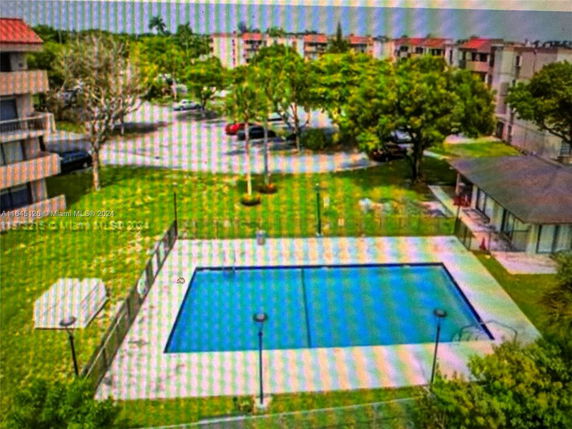 Outdoor swimming pool area with surrounding buildings and trees