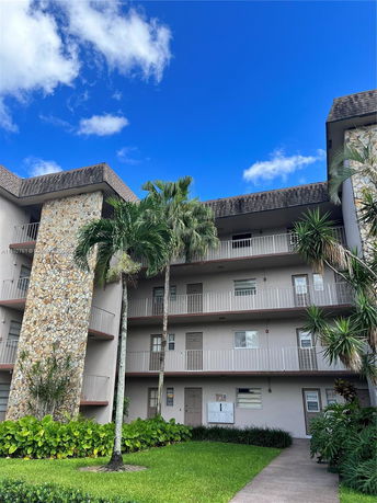 Front view of a multi-story residential building with balconies and stone accents.