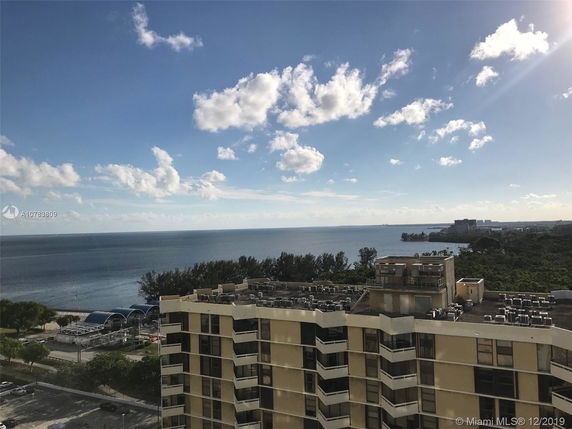 Wide angle view overlooking a coastal cityscape with a body of water and clear sky.