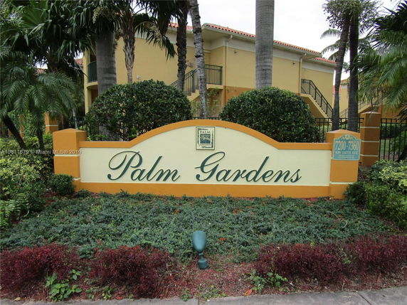 Front view of a residential building with a sign reading 'Palm Gardens'.