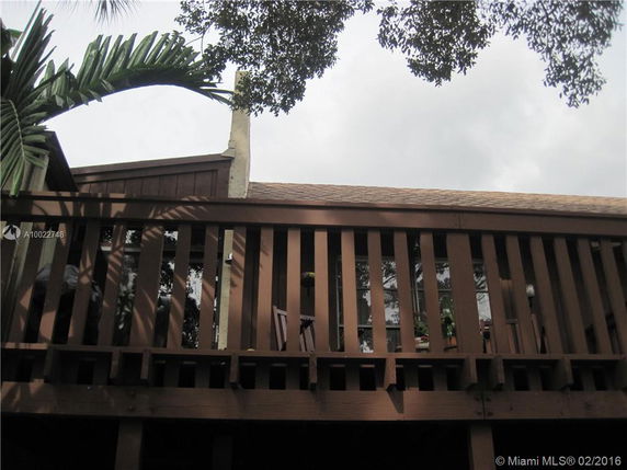 Front view of a house with a wooden balcony and chimney.