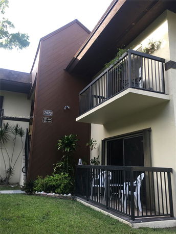 Front view of a building with multiple balconies and brown paneling.