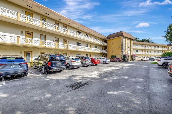 Outdoor parking area in front of a multi-story residential building.