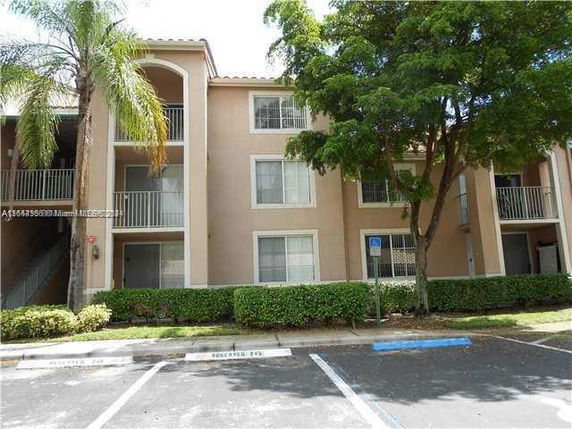 Front view of a three-story apartment building with balconies.