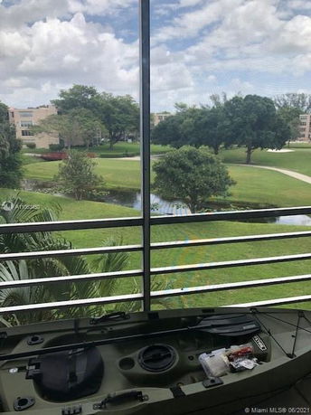 View of green landscape and trees from a balcony with metal railing.