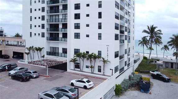 Front view of a multi-story building with balconies and large windows.