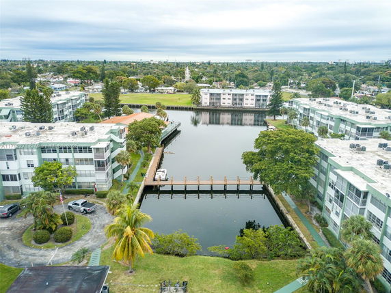 Aerial view of an apartment complex with a central waterway and surrounding greenery.