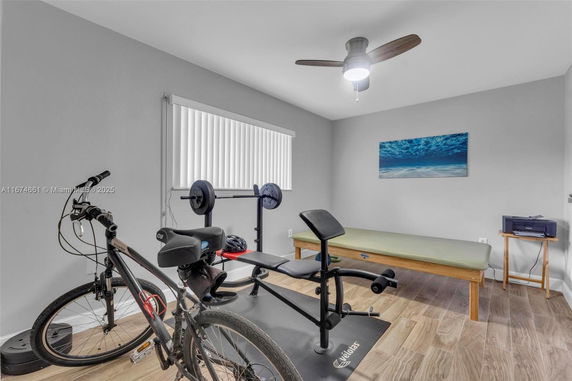 Indoor home gym with exercise bike and weight bench.