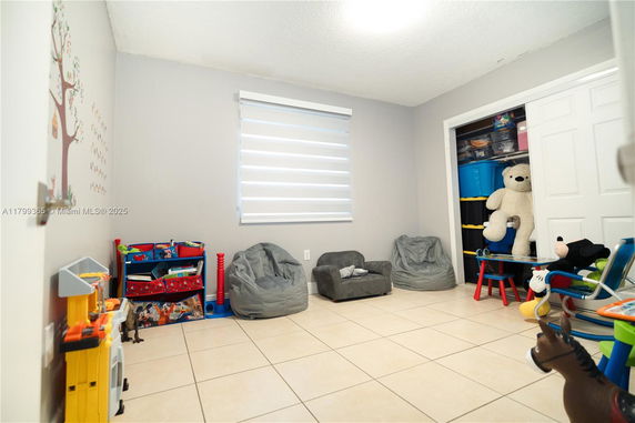 Room with toys, bean bags, and a small bookshelf.