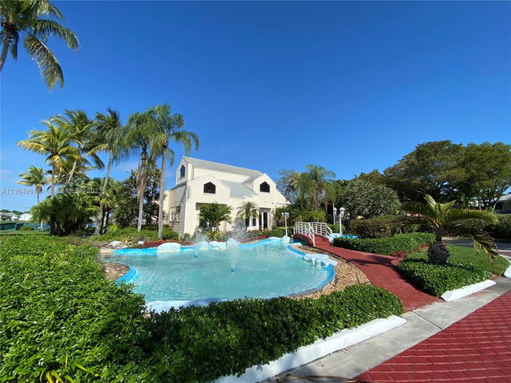 Front view of a two-story house with a decorative water feature in front.