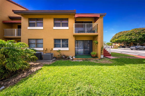 Front view of a two-story building with a balcony and stairs.