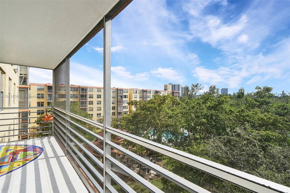 View from a balcony overlooking buildings and trees.