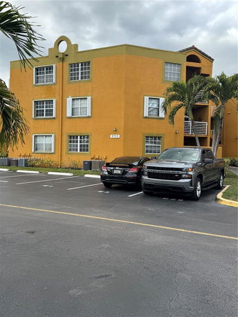 Parking area in front of a multi-story building.