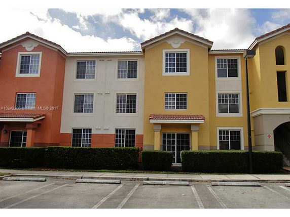 Front view of a three-story residential building with colorful exterior.