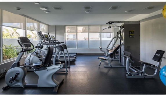 Indoor gym area with exercise equipment including treadmills and weight machines.