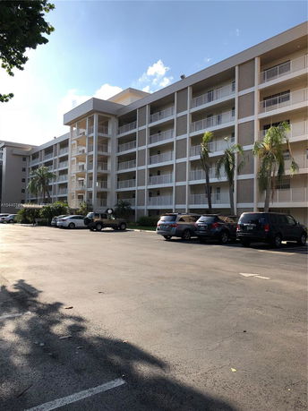 Front view of a multi-story apartment building with balconies.
