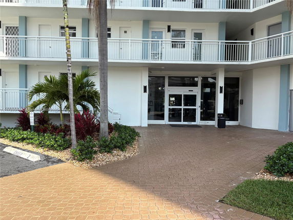 Front view of a multi-story building with balconies and a main entrance.