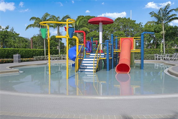 Outdoor play area with water features and slides in a pool.