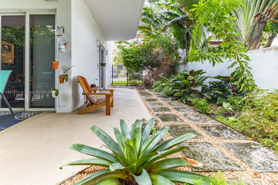 Outdoor patio area with a walkway and lush greenery.