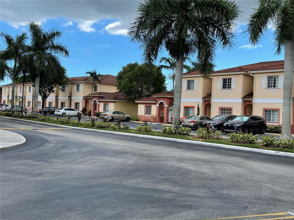 Front view of two-story residential buildings with parking spaces in front.